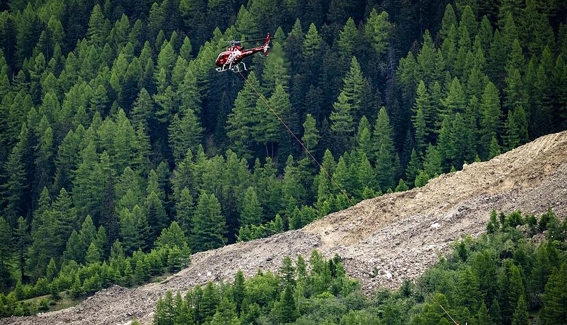 Ein Helikopter der Air Zermatt fliegt über einer Alp. Ein Helikopter der Air Zermatt fliegt über einer Alp.