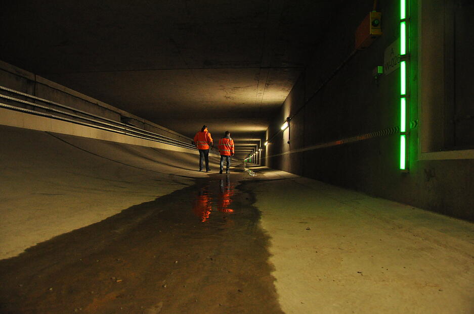 Deshalb wurden schon beim Bau die Wände verstärkt, sie sind bis zu drei Meter dick. Doch jetzt besteht dringender Handlungsbedarf. Anhydrit ist ein Mineral, das nach Kontakt mit Wasser aufquillt. Es drückt nun nicht mehr nur von unten auf das Tunnelbauwerk, wie einkalkuliert worden war. Problem gibt es nun auch von den Seiten, insbesondere auf 175 Meter der 2,5 Kilometer langen Röhren. Hier muss das Bauwerk saniert werden. Die Vorbereitungen laufen in diesen Abluftschächten unter der eigentlichen Fahrbahn. Deshalb wurden schon beim Bau die Wände verstärkt, sie sind bis zu drei Meter dick. Doch jetzt besteht dringender Handlungsbedarf. Anhydrit ist ein Mineral, das nach Kontakt mit Wasser aufquillt. Es drückt nun nicht mehr nur von unten auf das Tunnelbauwerk, wie einkalkuliert worden war. Problem gibt es nun auch von den Seiten, insbesondere auf 175 Meter der 2,5 Kilometer langen Röhren. Hier muss das Bauwerk saniert werden. Die Vorbereitungen laufen in diesen Abluftschächten unter der eigentlichen Fahrbahn.