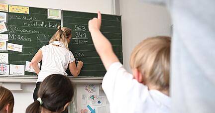 Sch&uuml;ler einer Grundschule arbeiten in einem Klassenzimmer an Mathematikaufgaben.