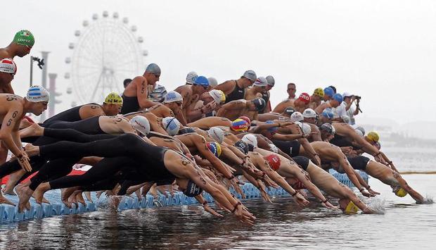 Die Freischwimmer springen vor dem Riesenrad von Shanghai ins Wasser.