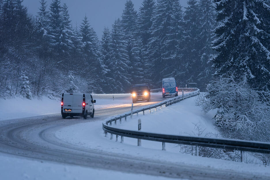 Autos fahren bei Vöhrenbach auf einer von Schnee bedeckten Straße. Autos fahren bei Vöhrenbach auf einer von Schnee bedeckten Straße.