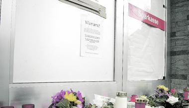 Mit Blumen und Kerzen haben trauernde und betroffene Menschen mittlerweile die Eingangstür des Siegelsbacher Filiale der Sparkasse Kraichgau geschmückt, um ihr Mitgefühl auszudrücken.
