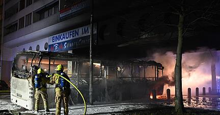 Feuerwehrmänner löschen an der Berliner Sonnenallee einen Reisebus, der in der Silvesternacht von Unbekannten angezündet wurde.