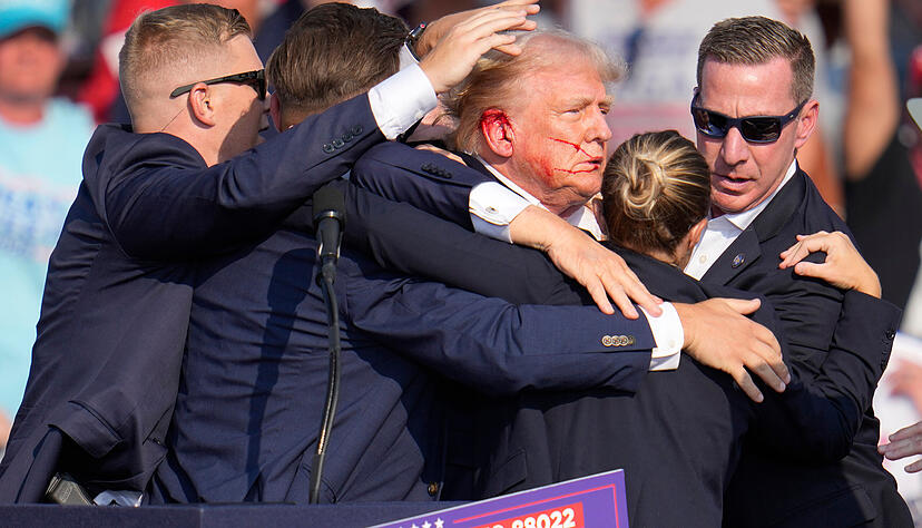 14.07.2024, USA, Butler: Der republikanische Präsidentschaftsbewerber und frühere US-Präsident Donald Trump wird von Agenten des US-Geheimdienstes Secret Service umringt, als ihm bei einer Wahlkampfveranstaltung von der Bühne geholfen wird. Trump wurde während des Wahlkampfes attackiert.
Sicherheitsleute umringen den Politiker Donald Trump, nachdem er verletzt worden war. (zu dpa: «Biden kündigt nach Attentat unabhängige Untersuchung an») Foto: Gene J. Puskar/AP/dpa +++ dpa-Bildfunk +++