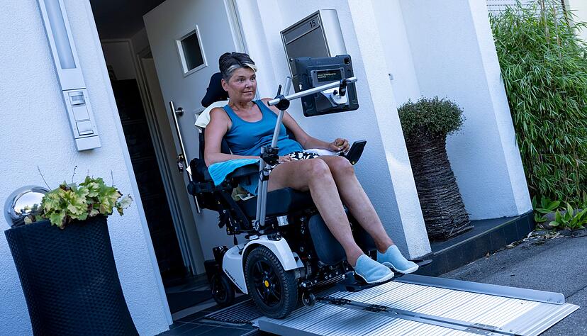 Gabriele Engel f&auml;hrt mit ihrem Rollstuhl &uuml;ber eine Rampe aus ihrem Haus.