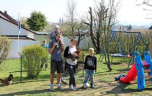 Nichts wie raus in den Garten: Stephanie Genz und Christoph Seher mit den S&ouml;hnen Marco und Manuel, in sicherem Abstand lugt Nachbarsjunge Silvan durchs Geb&uuml;sch.