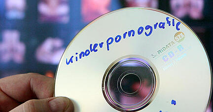 Ein Fahnder hält eine CD mit kinderpornografischem Material in der Hand. Symbolfoto: dpa