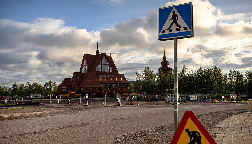 Vor der Kiruna-Kirche, einer schwedisch-lutherischen Holzkirche im samischen Stil werden Bauschilder aufgestellt – die Umsiedlung der Stadt auf einer fünf Kilometer langen Strecke steht bevor. Vor der Kiruna-Kirche, einer schwedisch-lutherischen Holzkirche im samischen Stil werden Bauschilder aufgestellt – die Umsiedlung der Stadt auf einer fünf Kilometer langen Strecke steht bevor.