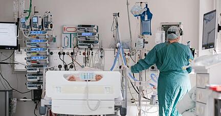 Eine Intensivpflegerin versorgt auf der Intensivstation einen an Covid-19 erkrankten Patienten.