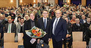 Landrat Norbert Heuser (rechts) verabschiedete Julia und Rainer Gr&auml;&szlig;le mit Blumen und einer Reisetasche &ndash; vielleicht einmal f&uuml;r die Abreise am Talheimer Bahnhof.