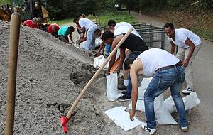 Asylbewerber füllen Sandsäcke. Foto: Asylbewerber füllen Sandsäcke. Foto: