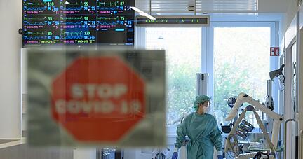 Eine Intensivpflegerin l&auml;uft in der Corona-Intensivstation des Universit&auml;tsklinikums Dresden &uuml;ber den Gang.