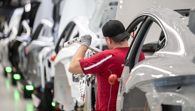 Ein Porsche-Mitarbeiter arbeitet im Stammwerk in Zuffenhausen an einem einen vollelektrischen Taycan. Die Nutzung von Privathandys wird nun auf die Pausenzeitenbeschr&auml;nkt.