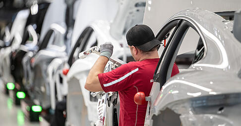 Ein Porsche-Mitarbeiter arbeitet im Stammwerk in Zuffenhausen an einem einen vollelektrischen Taycan. Die Nutzung von Privathandys wird nun auf die Pausenzeitenbeschr&auml;nkt.
