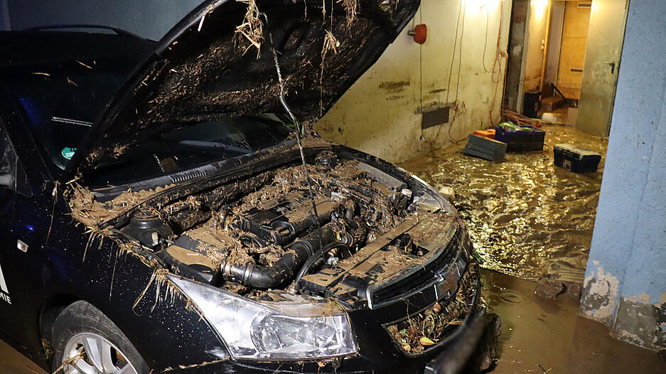 Sch&auml;den von &Uuml;berschwemmungen sind im Landkreis Karlsruhe an einem&nbsp;Auto und einem Haus sichtbar.