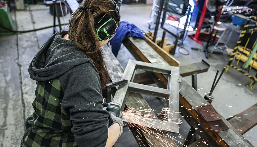 Eine Auszubildende zum Metallbauer arbeitet mit einem Schleifger&auml;t.