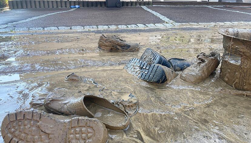 Verdreckte Schuhe liegen im Schlamm, der sich in Teilen Gemmingens nach einem Unwetter zeigt.