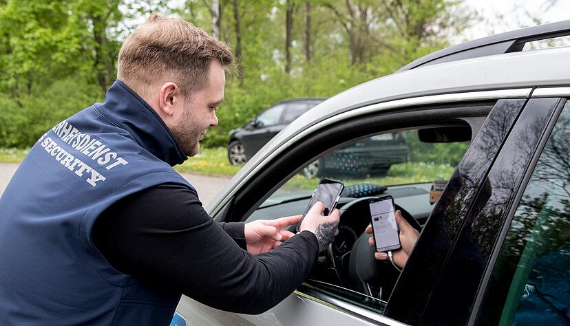 An der Zufahrt zu den Parkpl&auml;tzen kontrolliert ein Mitarbeiter der Firma SJS die online gebuchten Eintritts- und Parktickets der Besucher.