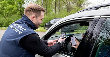 An der Zufahrt zu den Parkplätzen kontrolliert ein Mitarbeiter der Firma SJS die online gebuchten Eintritts- und Parktickets der Besucher.