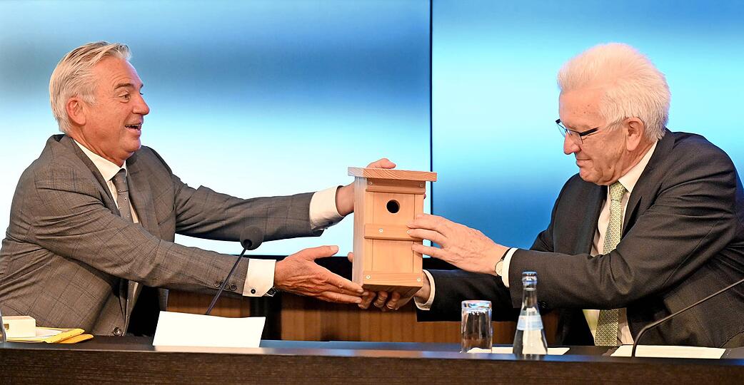Innenminister Thomas Strobl (links) &uuml;berreicht Ministerpr&auml;sident Winfried Kretschmann ein Vogelh&auml;uschen als Geschenk.
Foto: dpa