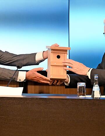 Innenminister Thomas Strobl (links) &uuml;berreicht Ministerpr&auml;sident Winfried Kretschmann ein Vogelh&auml;uschen als Geschenk.
Foto: dpa