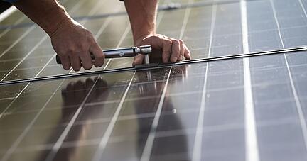 Mitarbeiter montieren Photovoltaikmodule auf dem Dach eines Wohnhauses. Die Nachfrage zu den Angeboten der Energieberatung ist stark gestiegen.