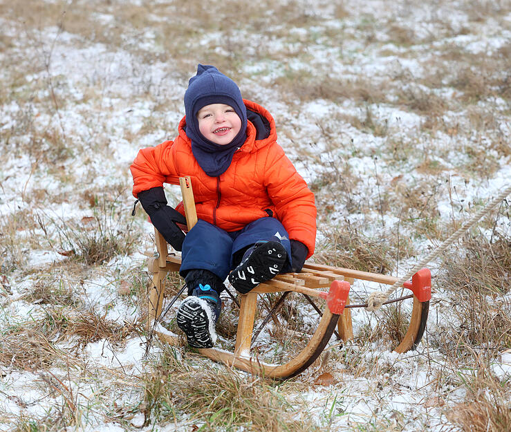 Kinder und Erwachsene genie&szlig;en Rodelspa&szlig; in der winterlichen Landschaft.
