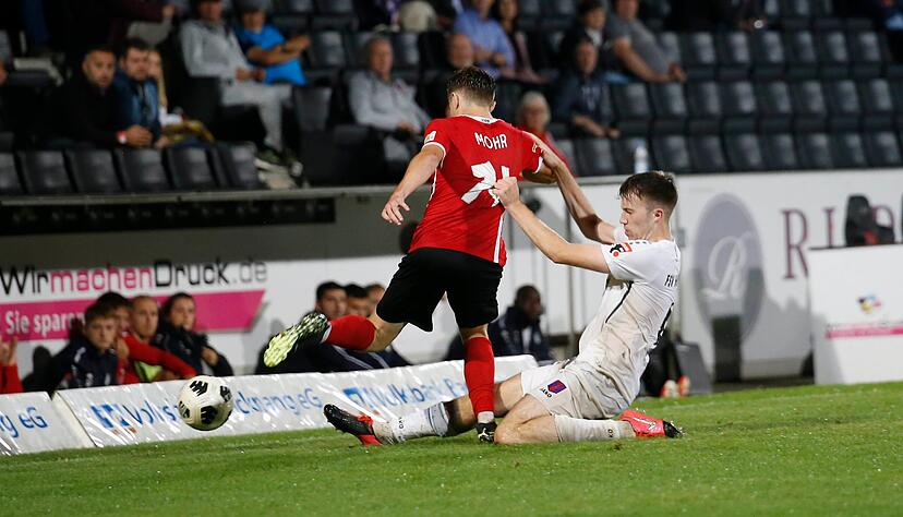 Matthias Hahn vom FSV Hollenach (weißes Trikot) grätscht in der Partie gegen die SG Sonnenhof  Großaspach.