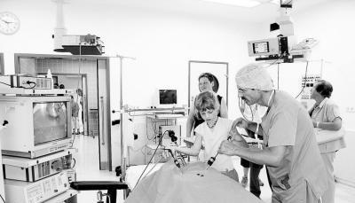 Oberarzt Sven Unger assistiert der neunjährigen Nachwuchs-Chirurgin Anna Bühler, die mit Hilfe des Laparoskops und viel Fingerspitzengefühl ein paar Gummibärchen aus einer roten Paprika operiert. (Fotos: Juergen Koch) Oberarzt Sven Unger assistiert der neunjährigen Nachwuchs-Chirurgin Anna Bühler, die mit Hilfe des Laparoskops und viel Fingerspitzengefühl ein paar Gummibärchen aus einer roten Paprika operiert. (Fotos: Juergen Koch)