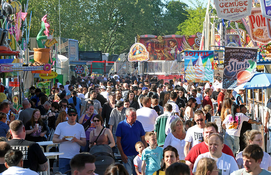Besucher schlendern &uuml;ber das Volksfest auf der Theresienwiese in Heilbronn.
