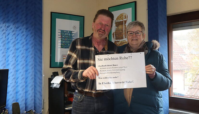 J&uuml;rgen Pr&uuml;mmer hat schon vor vielen Jahren dieses Schild zum 1. Mai an das Ortsschild geh&auml;ngt. Viel getan hat sich - zumindest in Sachen Handyempfang - nichts. Festnetz und Internet ist besser als an vielen anderen Orten. Mit Ortsvorsteherin Monika Baumann h&auml;lt er das Schild hoch