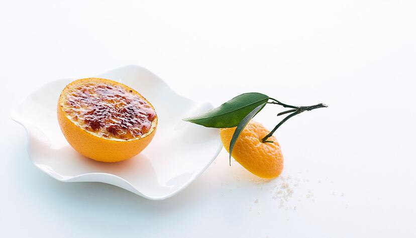 Ein Hingucker: Der gebrannte Orangen-Gew&uuml;rz-Joghurt wird bei Johann Lafer in der ausgeh&ouml;hlten Orangenh&auml;lfte serviert.