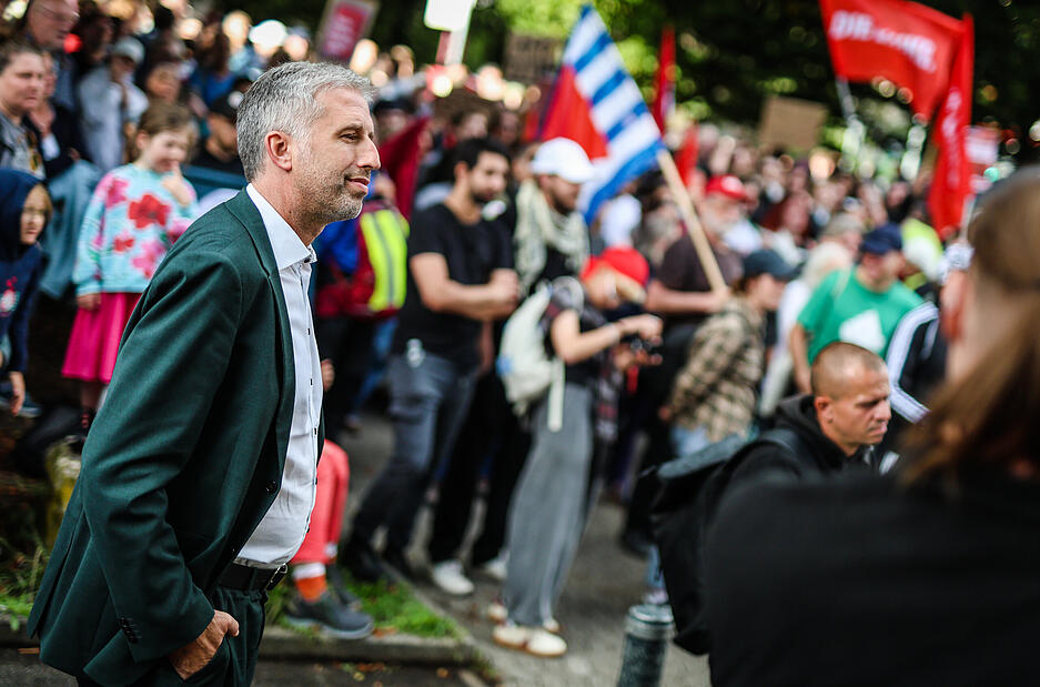 Tübingens Oberbürgermeister Boris Palmer (Parteilos, vorne l) kommt zu seiner Diskussionsrunde mit dem AfD-Landesvorsitzendem Frohnmaier zum Austragungsort, der Hermann-Hepper-Halle, vor der eine Demonstration der Linken gegen die AfD stattfindet.