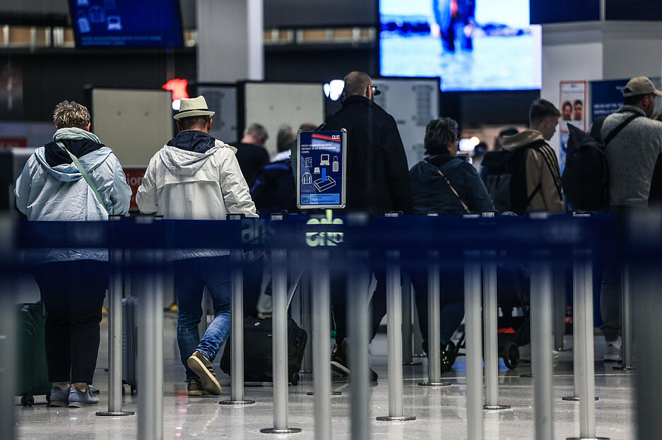 Passagiere gehen am Flughafen Düsseldorf zur Sicherheitskontrolle. Dort sind nicht alle Flüge am Donnerstag gestrichen. Passagiere gehen am Flughafen Düsseldorf zur Sicherheitskontrolle. Dort sind nicht alle Flüge am Donnerstag gestrichen.