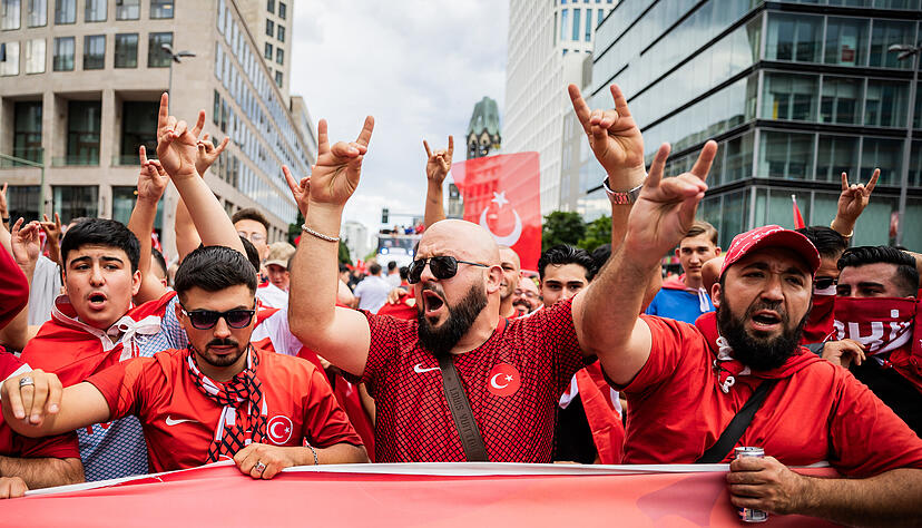 Türkei-Fans zeigen bei einem Fanmarsch Richtung Olympiastadion den «Wolfsgruß», dessen Ursprung einer rechtsextremistischen Bewegung zugeordnet wird. Türkei-Fans zeigen bei einem Fanmarsch Richtung Olympiastadion den «Wolfsgruß», dessen Ursprung einer rechtsextremistischen Bewegung zugeordnet wird.