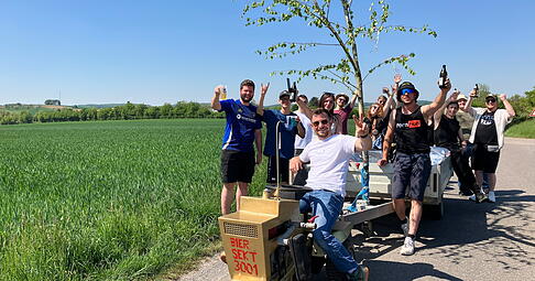 Mit einem goldenen Rasenm&auml;hertraktor ist die Gruppe von Schwabbach Richtung Pfedelbach unterwegs. Gut, dass kaltes Bier dabei ist.