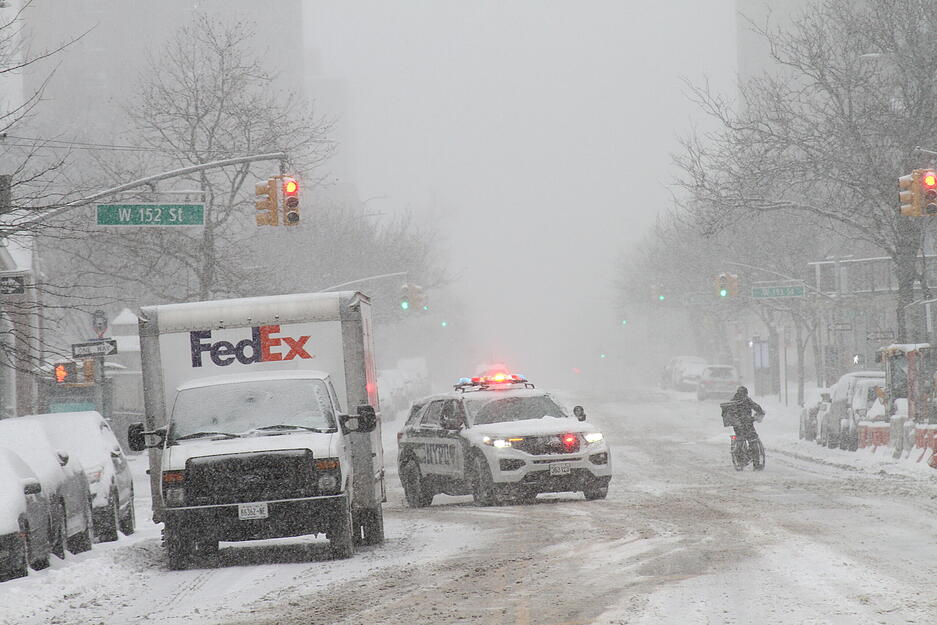 Ein Polizeiwagen patrouilliert auf einer schneebedeckten Straße in New York. Ein Polizeiwagen patrouilliert auf einer schneebedeckten Straße in New York.