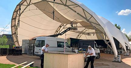 Vor der imposanten Kulisse der Hauptbühne: Mitarbeiter der Firma Mack und Fischer aus Eppingen "entschärfen" stolperträchtige Abspannseile, indem sie Außentresen herum bauen. Vor der imposanten Kulisse der Hauptbühne: Mitarbeiter der Firma Mack und Fischer aus Eppingen "entschärfen" stolperträchtige Abspannseile, indem sie Außentresen herum bauen.