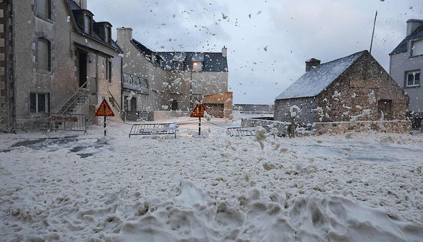 Schaum und Gischt fließen über eine Straße in Penmarch, Westfrankreich, als der Sturm Ciaran über die Region zieht.