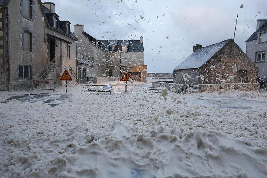 Schaum und Gischt fließen über eine Straße in Penmarch, Westfrankreich, als der Sturm Ciaran über die Region zieht.
