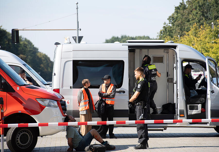 Ein Polizeibeamter steht am Brandenburger Tor um festgesetzte Mitglieder der Klimaschutzgruppe Letzte Generation.