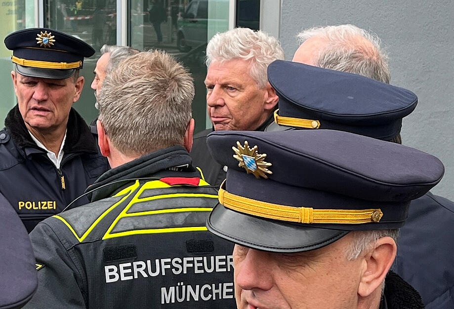Thomas Hampel (links), Polizeipräsident in München, und Dieter Reiter (SPD, hinten, r), Oberbürgermeister von München, informieren sich bei Feuerwehr und Polizei zum Einsatzgeschehen.