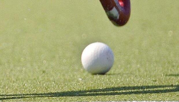 Ein Hockeschl&auml;ger f&uuml;hrt einen Ball.