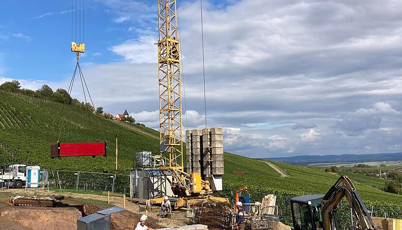 Der Kran senkt die rote Schalung für das Fundament in die Baugrube: Der neue Weinausschank nimmt Form an. Der Kran senkt die rote Schalung für das Fundament in die Baugrube: Der neue Weinausschank nimmt Form an.