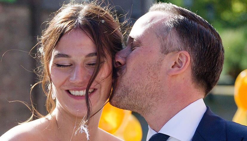 Nach der Hochzeit küsst Joe Laschet vor der Kirche seine Frau Andrea