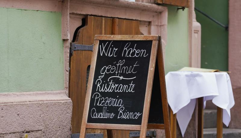 Ein Schild mit der Aufschrift ?Wir haben geöffnet? steht vor einem Restaurant in der Innenstadt. Ein Schild mit der Aufschrift ?Wir haben geöffnet? steht vor einem Restaurant in der Innenstadt.