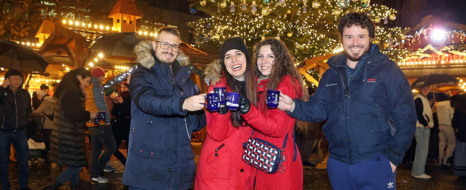 Besucher des Weihnachtsmarktes stoßen mit Heißgetränken auf die Eröffnung an. Besucher des Weihnachtsmarktes stoßen mit Heißgetränken auf die Eröffnung an.