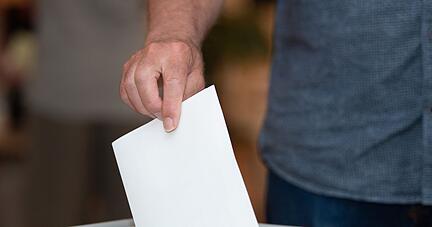 Ein Wähler wirft in einem Wahllokal seinen Stimmzettel in die Wahlurne.