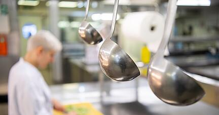 Eine Auszubildende zur Köchin arbeitet in einem Hotel in der Restaurantküche.