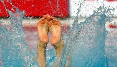 Ein Wasserspringerin taucht ein.